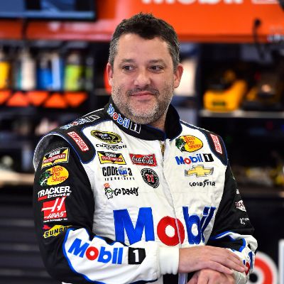 He is looking at something and has a smile on his face.